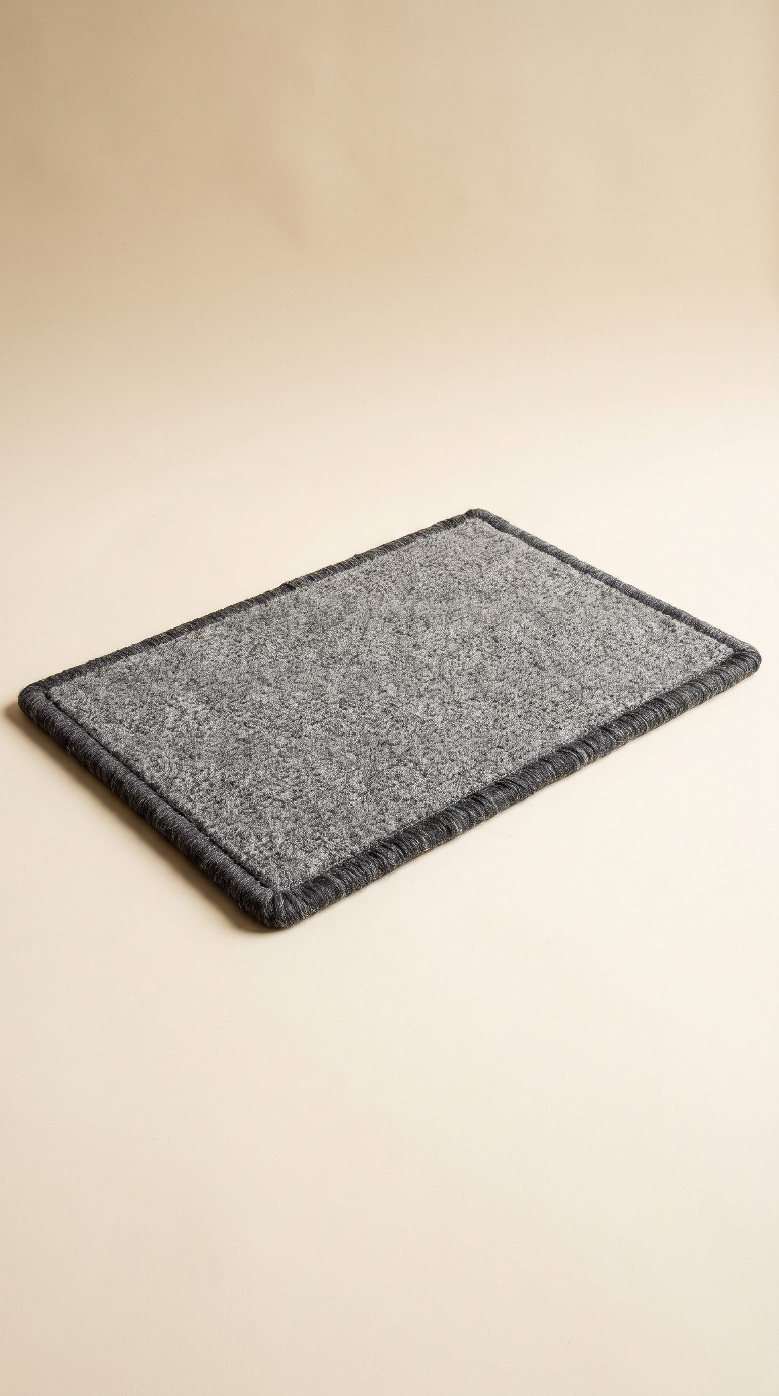 A grey wool doormat with whipped edges